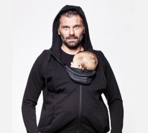 Un père porte son bébé en portage ventral